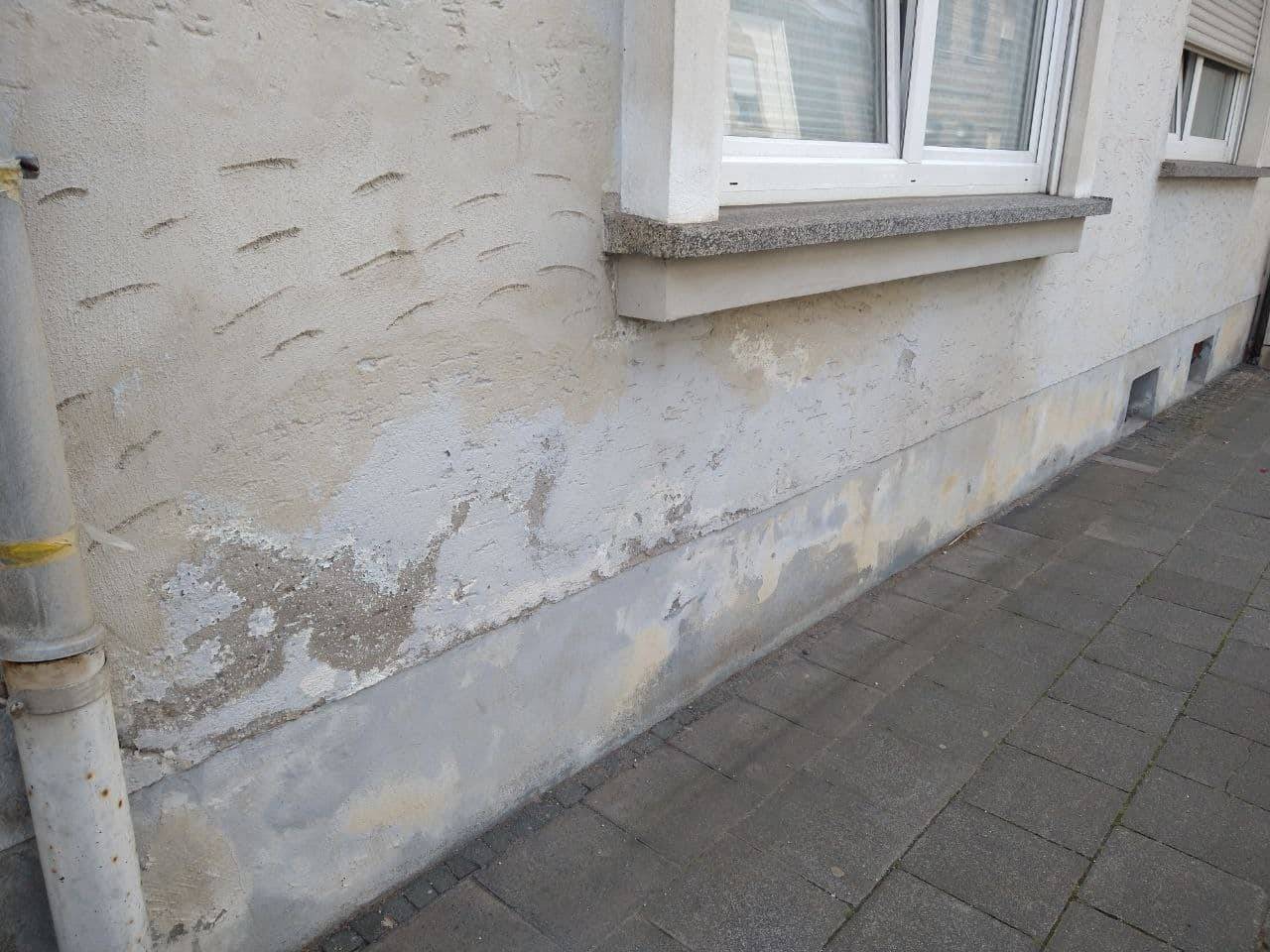 Wand Salpeter im Mauerwerk blüht außen an Fassade aus und zerstört den Sockelputz